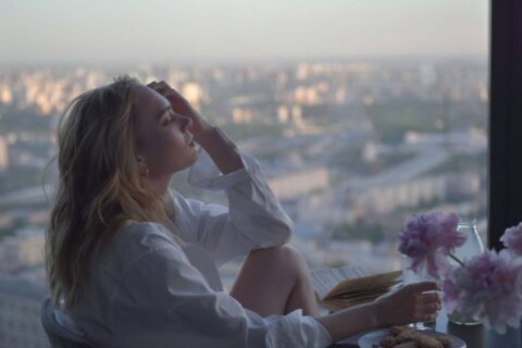 person looking out window searching for direction showing the journey of how to find a purpose in life