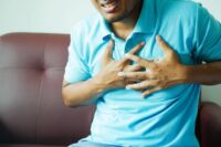 person holding chest in pain showing the physical reality of how to deal with heartbreak