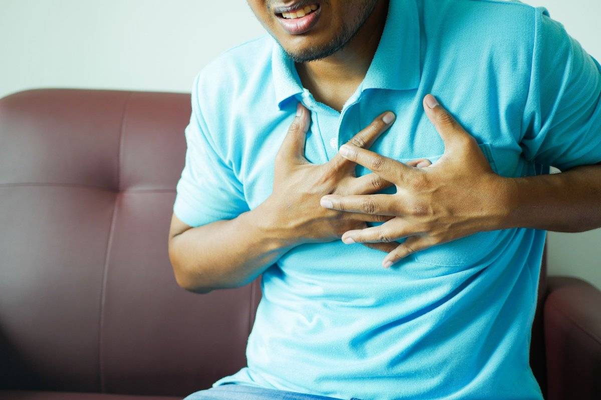 person holding chest in pain showing the physical reality of how to deal with heartbreak