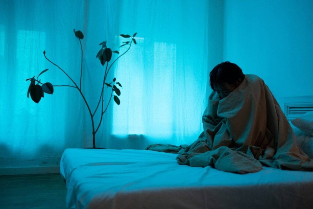 person lying awake at night exhausted showing the physical toll when learning how to deal with heartbreak