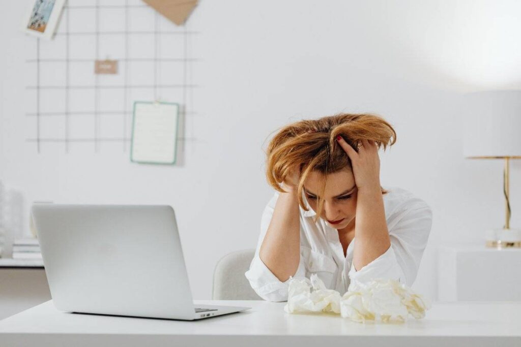 person overwhelmed with to-do list showing the gap addressed in how to stop being lazy