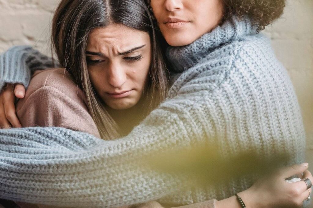 friend comforting person showing the support needed when learning how to deal with heartbreak
