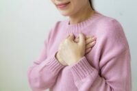 person placing hand over heart practicing self compassion exercises