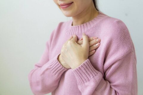 person placing hand over heart practicing self compassion exercises