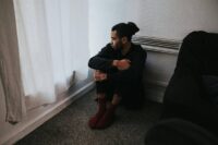 person sitting alone feeling lonely even when surrounded by people