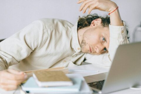 person sitting at desk exhausted and unmotivated struggling to get motivated