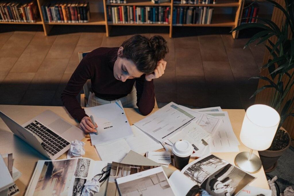 person sitting with unfinished work showing the cost of not learning how to overcome fear