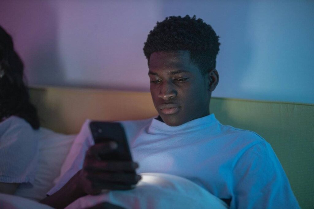 person checking phone at night showing what doesn't work when learning how to stop thinking of someone