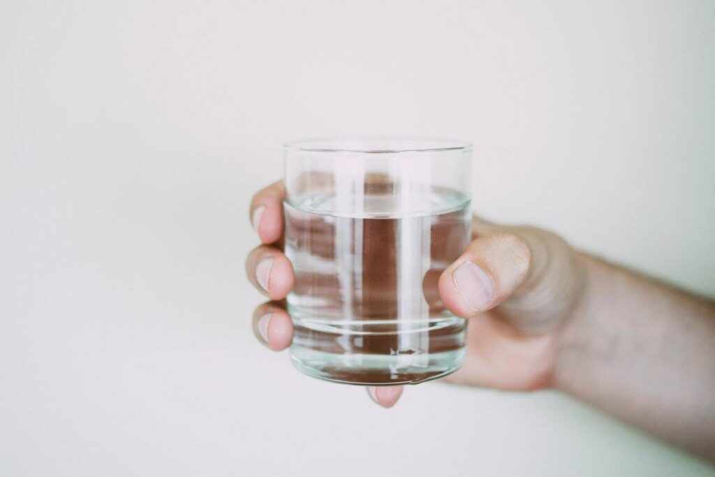 person drinking glass of water as part of healthy morning routine ideas