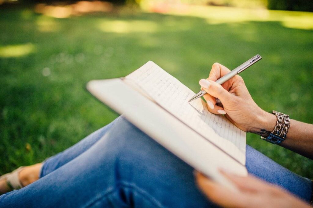 person writing in journal reconnecting with purpose to get motivated again