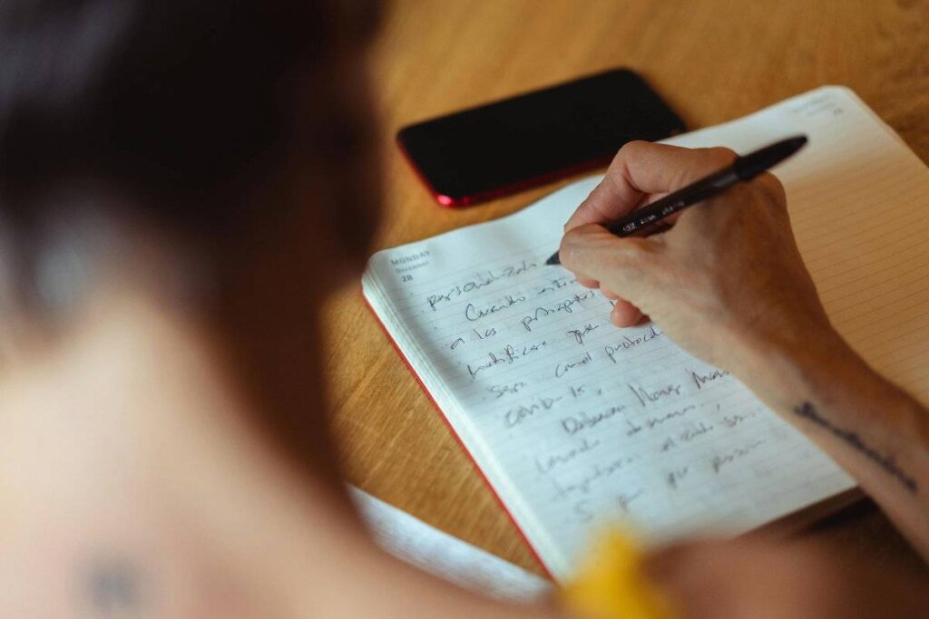 person writing in journal as part of learning how to forgive yourself