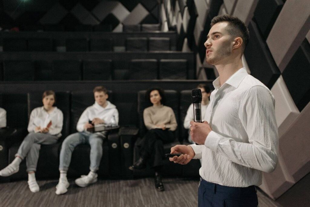person speaking calmly in group showing progress in learning how to be more confident