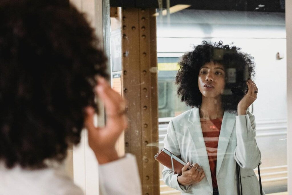person looking in mirror practicing how to build self confidence