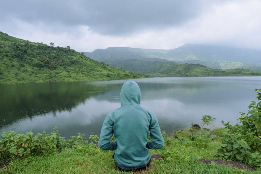 person sitting peacefully in nature after learning how to be more patient with life