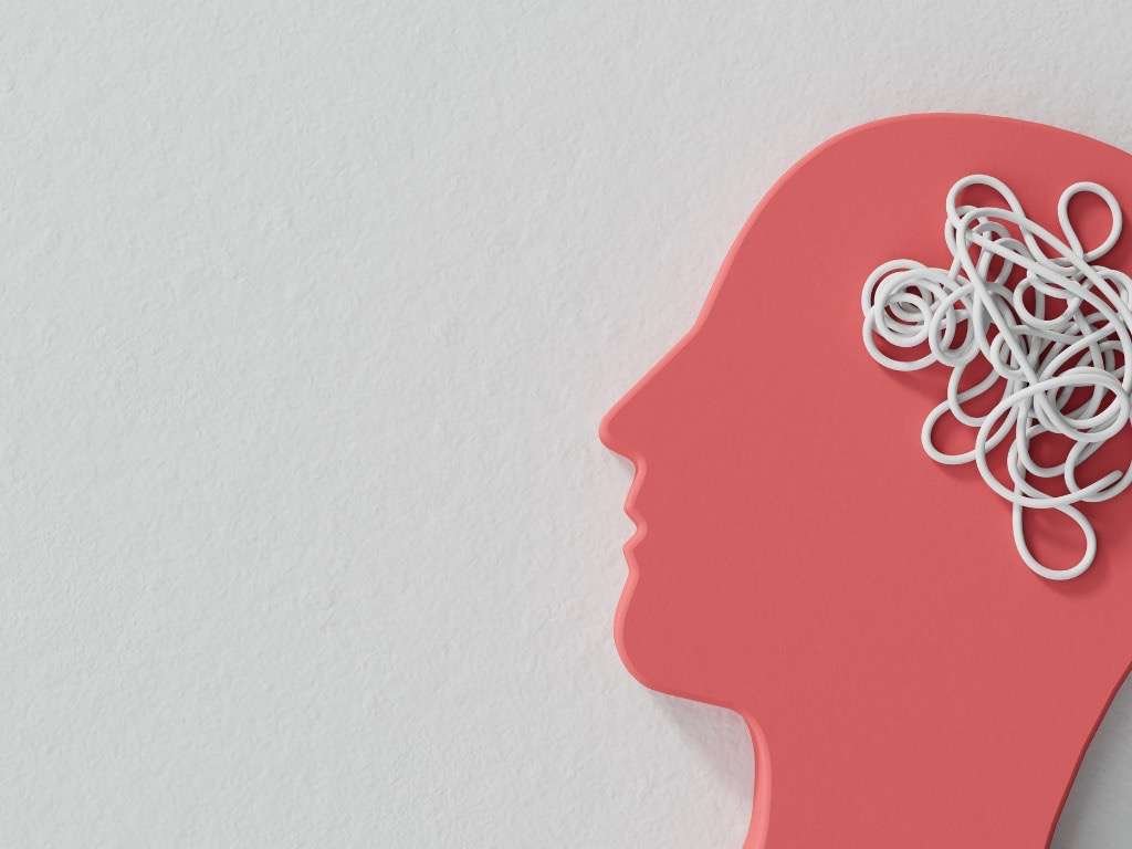 Silhouette of a red human head with tangled white lines inside, symbolizing mental health disorders and confusion on a light background.
