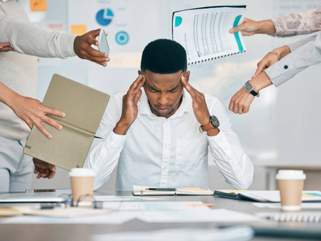 Managing stress and anxiety at work - overwhelmed man under pressure