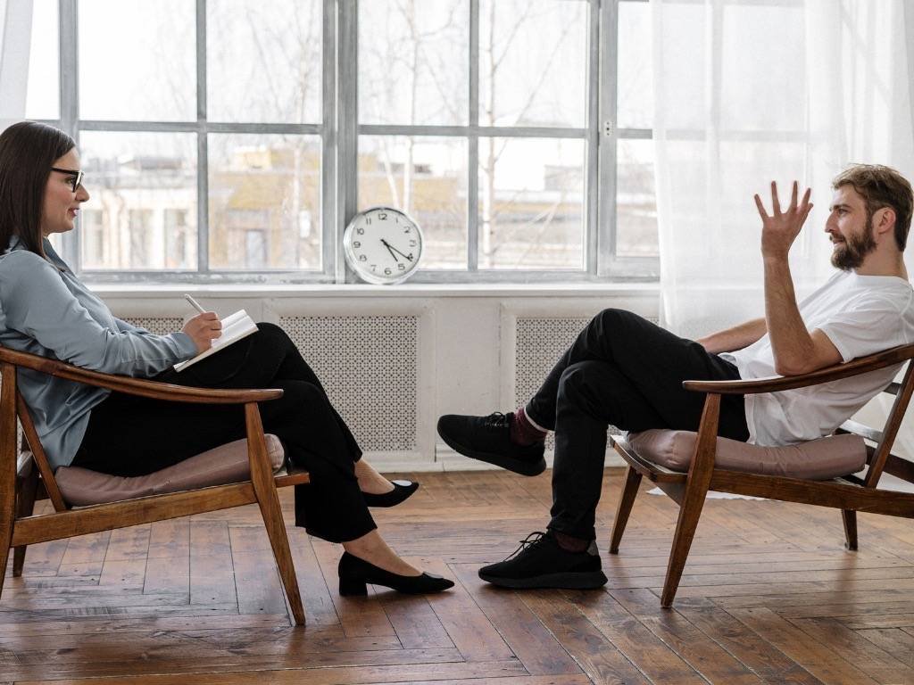 Man talking to a female therapist during a counseling session, highlighting mental health disorders treatment and professional support.