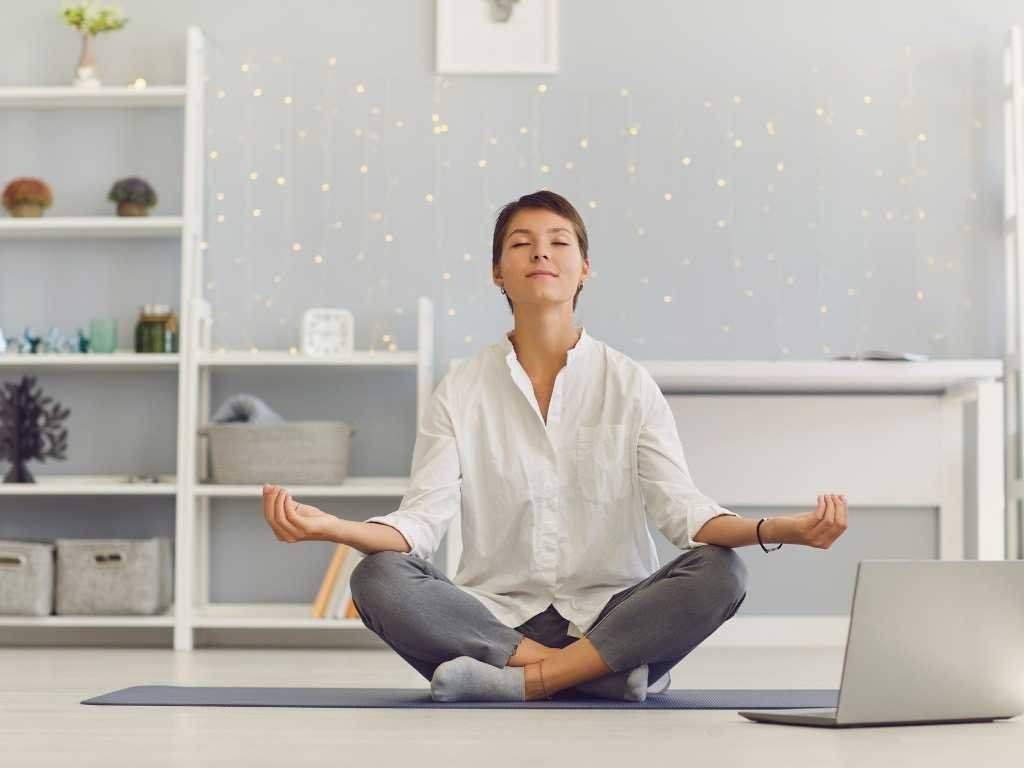 Woman practicing indoor yoga and meditation for better mental health and stress relief