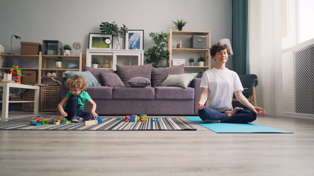 Mother Practicing Yoga and Boy Playing near