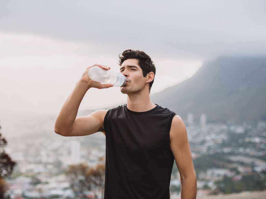 Man drinking water to stay hydrated and increase energy levels naturally