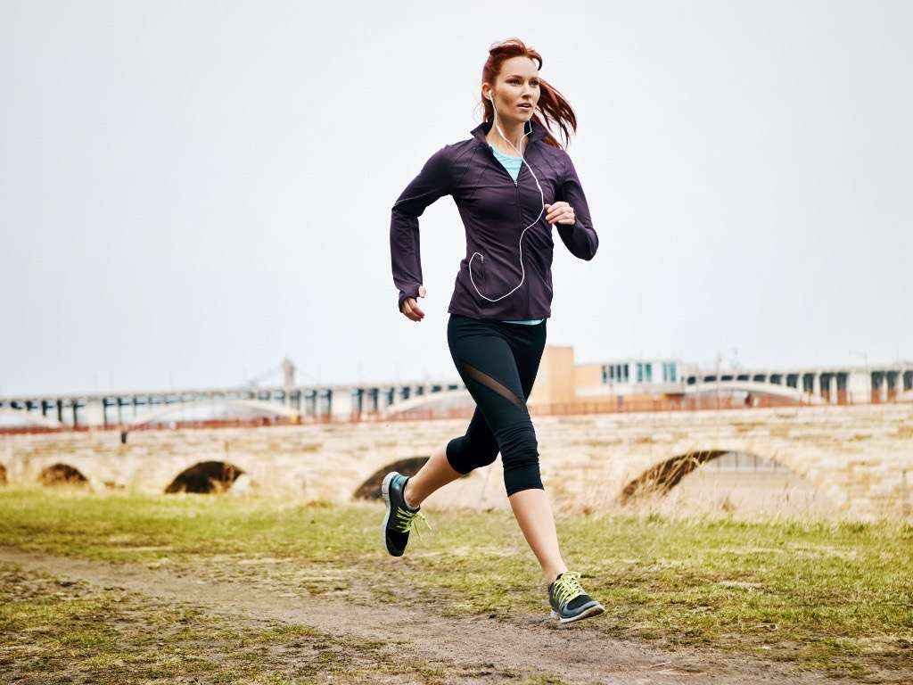 Woman running outdoors to increase energy levels and boost daily vitality naturally