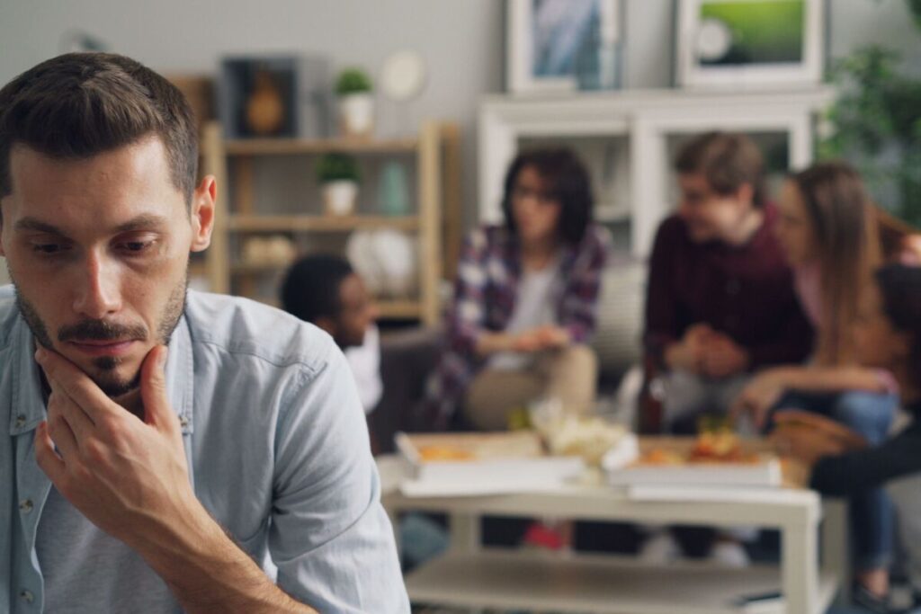 person in social setting thoughtful and observant showing awareness without anxiety in how to stop caring what people think