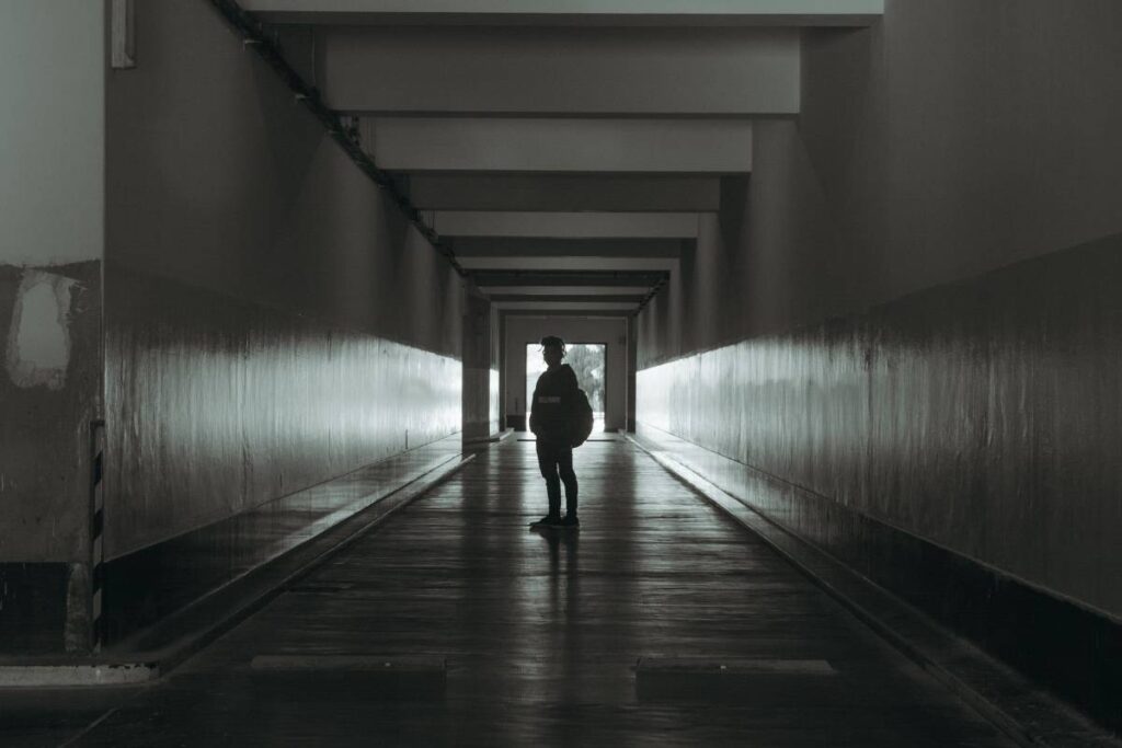 person standing still paused showing the paralysis described in how to get out of a rut
