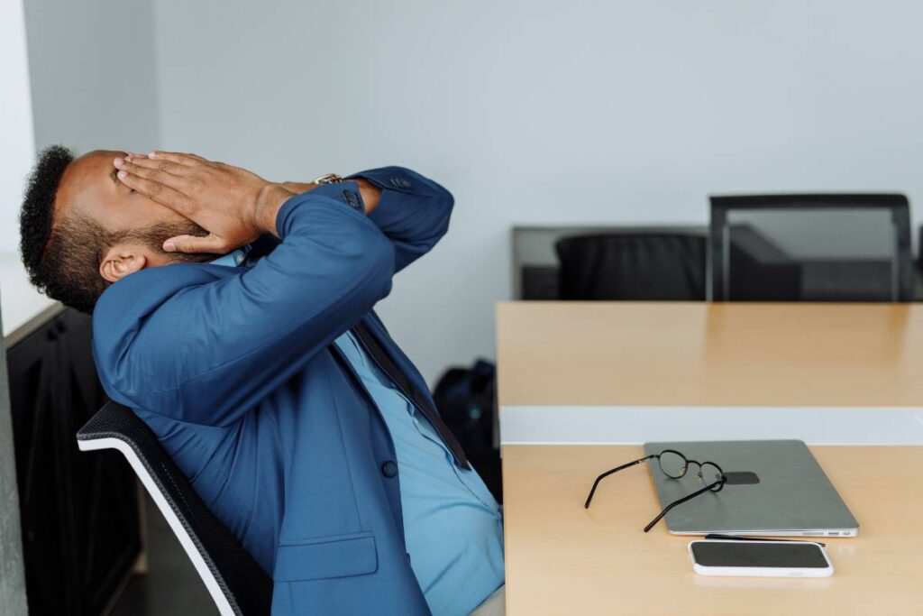 person exhausted at desk showing the personal cost of not knowing how to deal with a difficult coworker