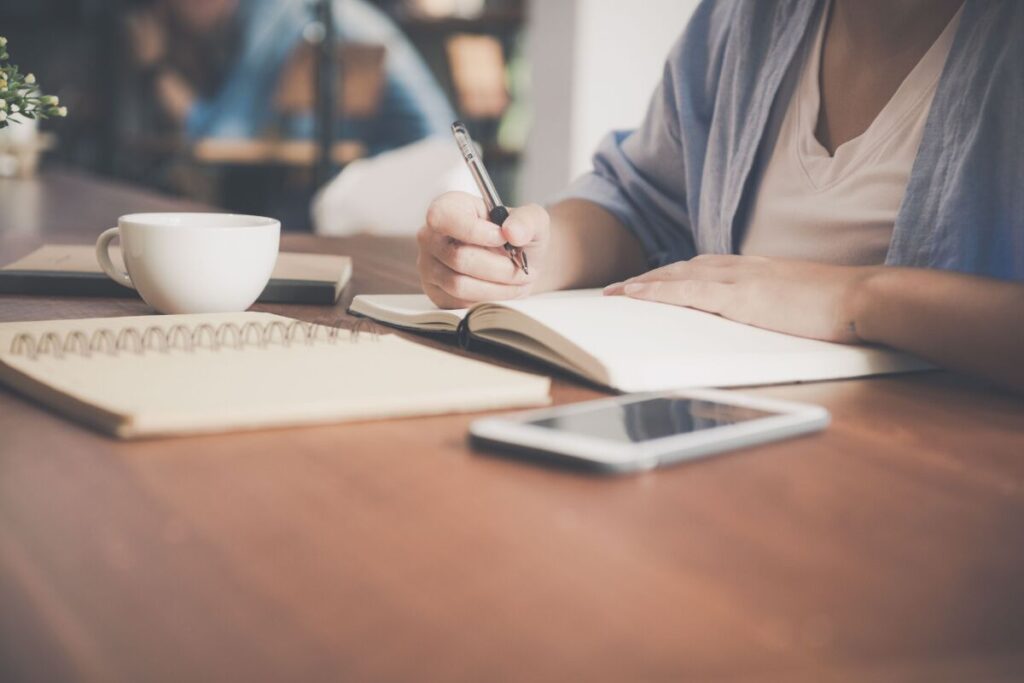 person writing honestly in journal showing the return to self that is central to how to stop caring what people think