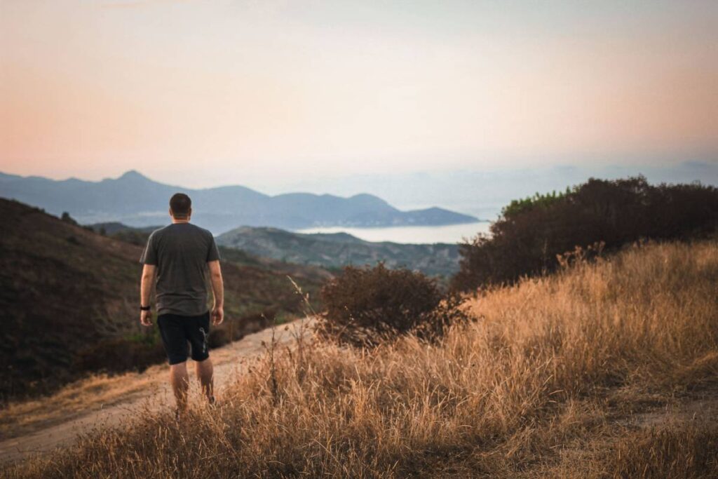 person looking back at path traveled showing the long journey of how to grow as a person