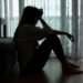 Woman sitting alone in a dark room, showing signs of silent depression and emotional struggle