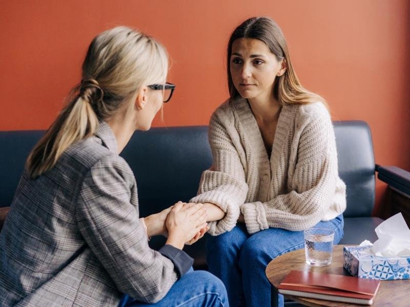 A woman talking with her therapist during a counseling session, representing the importance to find a psychologist for mental health support.
