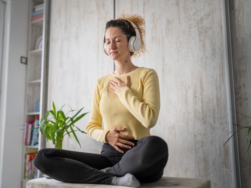 Young woman practicing mindfulness meditation at home as part of daily self-care practices