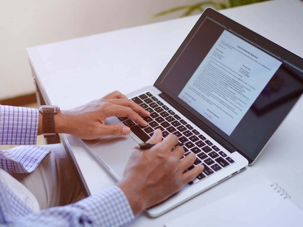 How to write effective articles – man typing on a laptop.