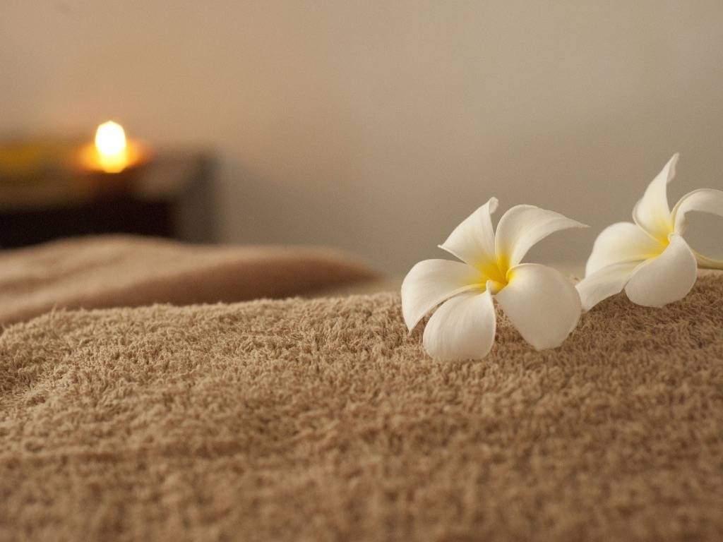 Spa relaxation with white tropical flowers and candlelight ambiance