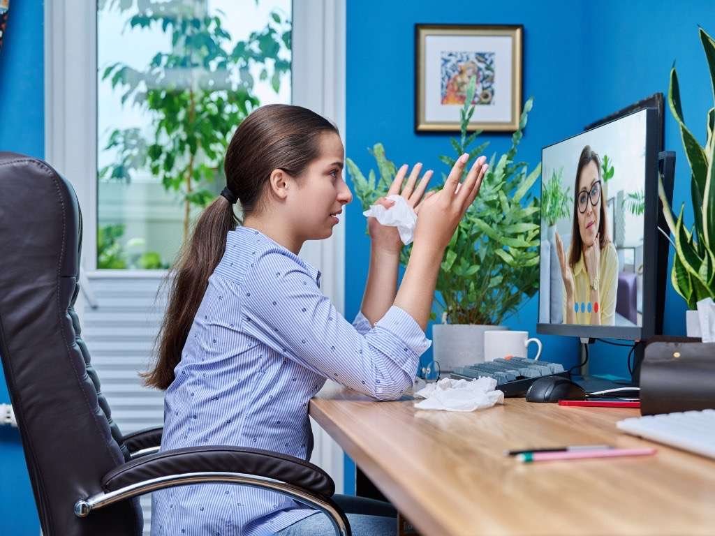 Online therapy session – woman talking to therapist on video call for mental health support