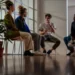“Group therapy session showing people sharing experiences, representing the benefits of therapy for mental health.