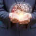 Positive mindset concept illustrated with a glowing brain in hands, symbolizing mental health, growth, and emotional well-being.
