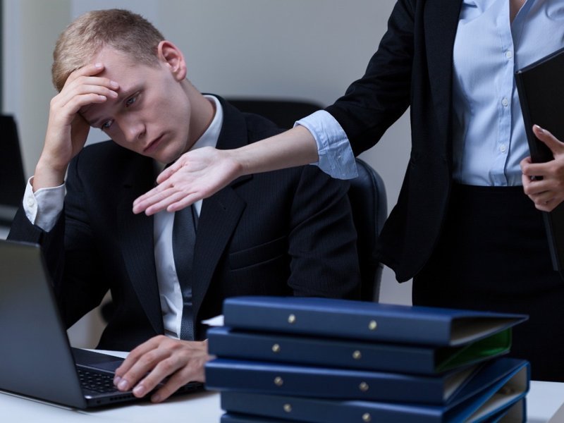 Stressed businessman receiving harsh criticism from a manager in the workplace