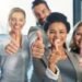 Group of smiling people showing thumbs up – example of toxic positivity in modern workplaces
