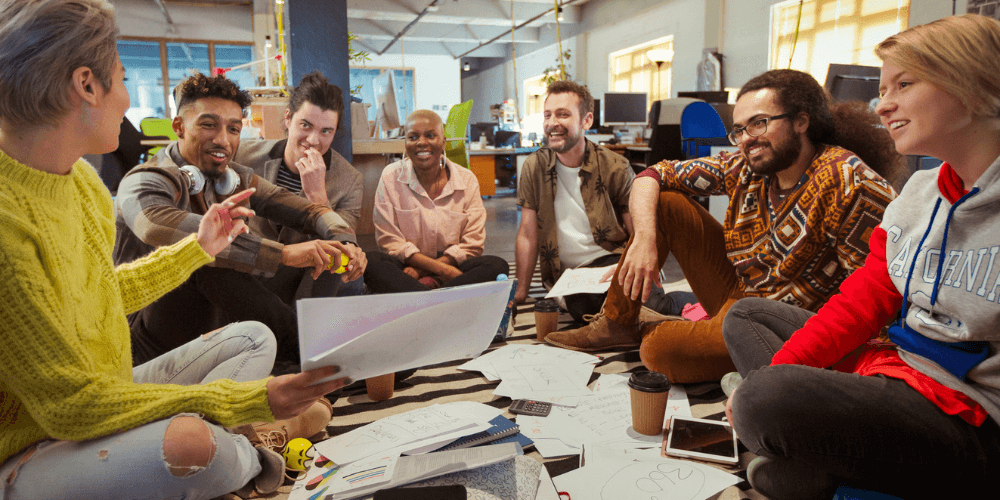 A diverse group of young adults sitting together in a casual setting, engaged in a lively group discussion.