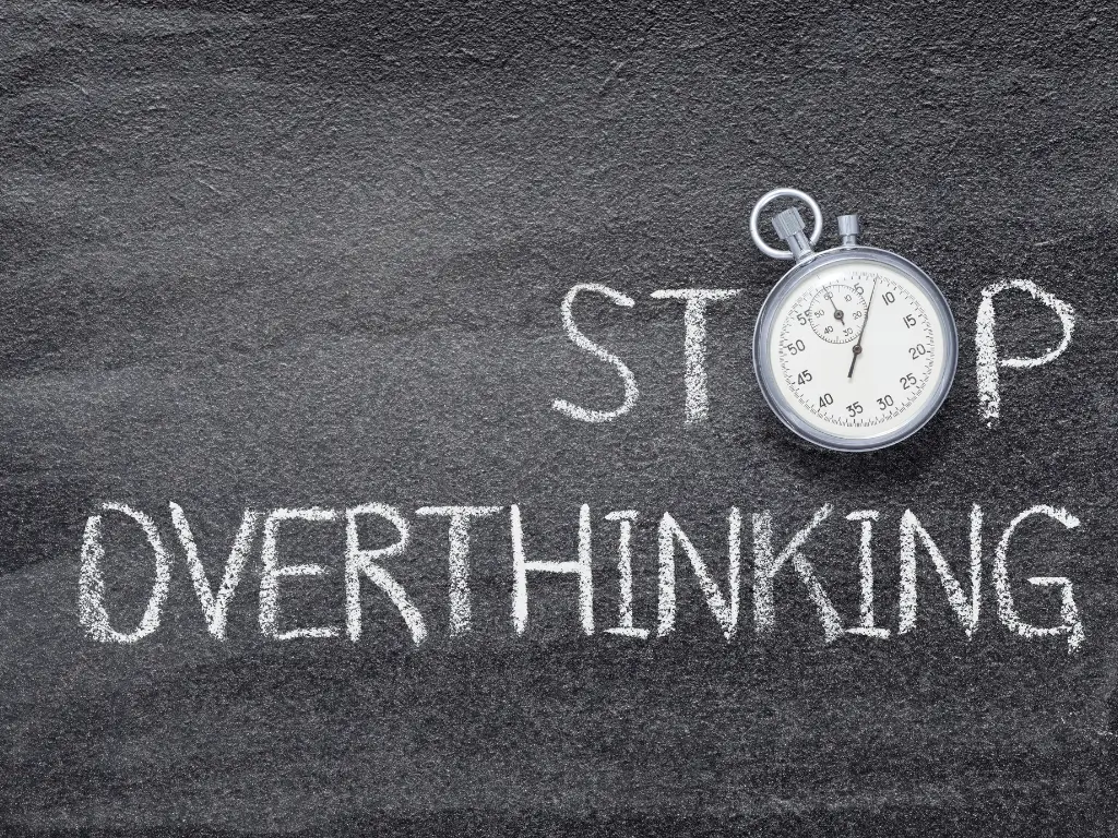 Chalkboard with 'Stop Overthinking' text and stopwatch – concept for reducing anxiety and stress