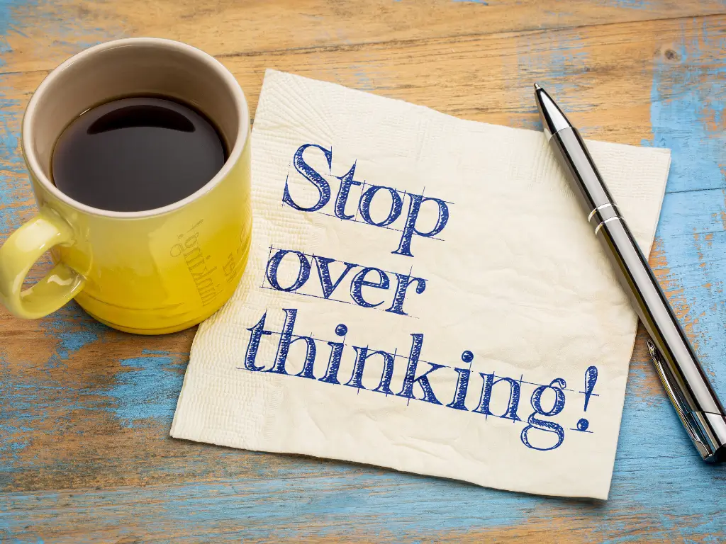 "Stop overthinking message on napkin with coffee cup – symbolizing relaxation and mental clarity