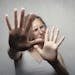 Fearful woman covering her face with hands, symbolizing anxiety and trying to stop overthinking.