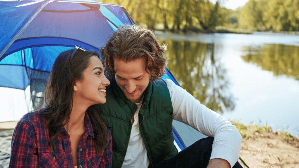 A couple smiling and communicating near a lake, illustrating how to improve your relationship through better communication and emotional connection.