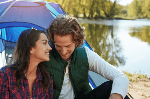 A couple smiling and communicating near a lake, illustrating how to improve your relationship through better communication and emotional connection.