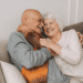 Happy senior couple showing physical intimacy on a cozy sofa, symbolizing emotional closeness and long-term love.