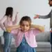Child covering ears during parents’ argument — symbolizing trauma bonding and emotional pain.