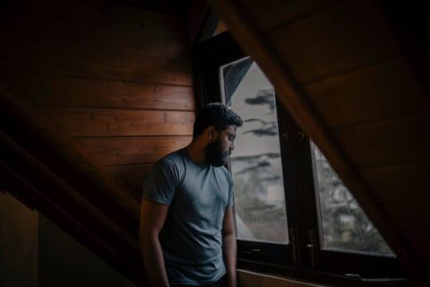 person sitting alone with quiet sadness showing the weight of recognizing signs of an unhealthy relationship