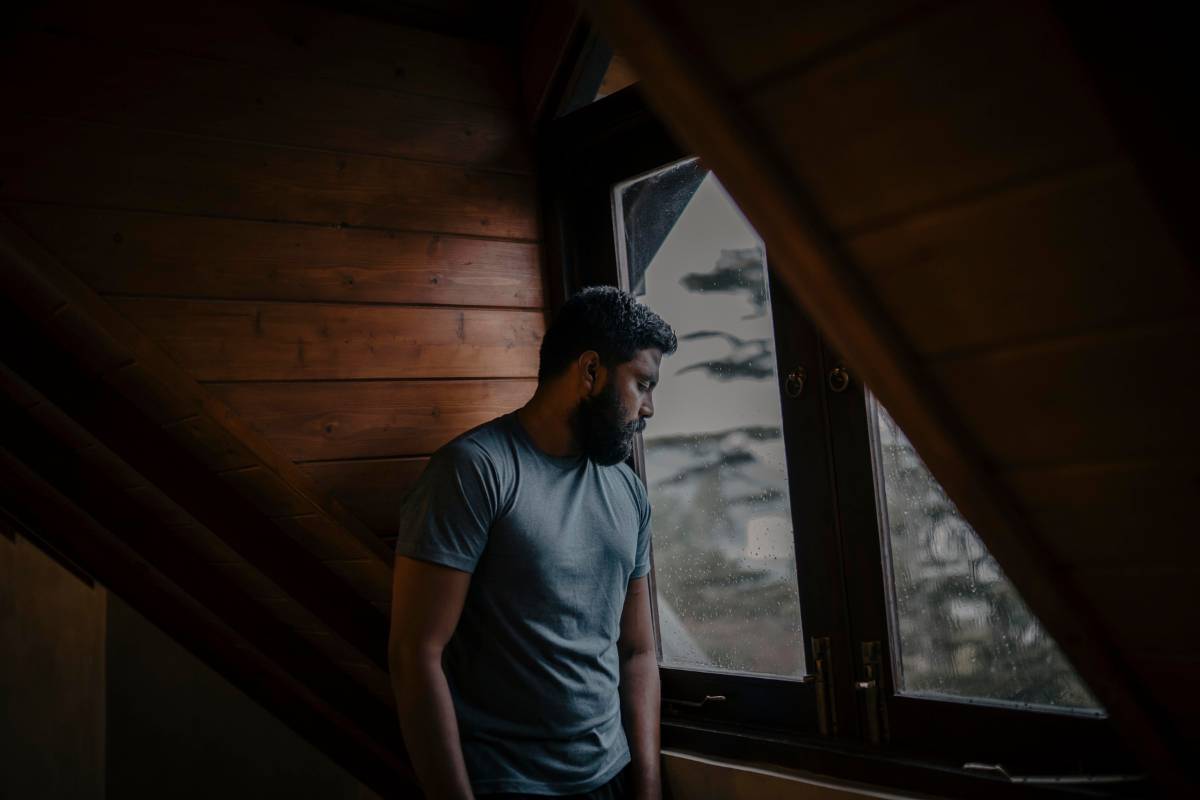 person sitting alone with quiet sadness showing the weight of recognizing signs of an unhealthy relationship